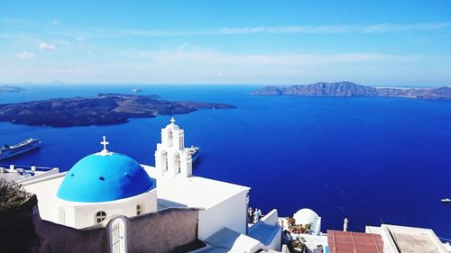 Panoramic view of sea and buildings against blue sky