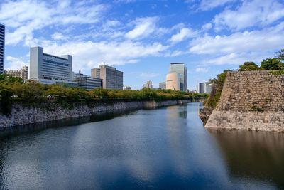 River amidst buildings in city against sky