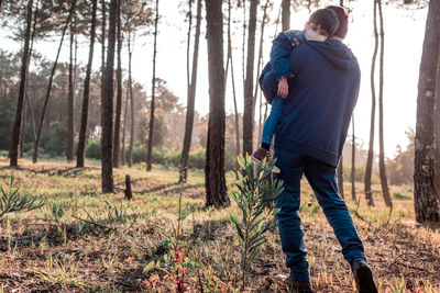 Rear view of man standing in forest