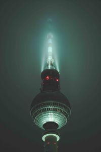 Low angle view of illuminated tower against sky at night