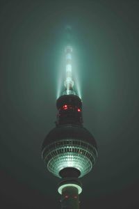 Low angle view of illuminated tower against sky at night