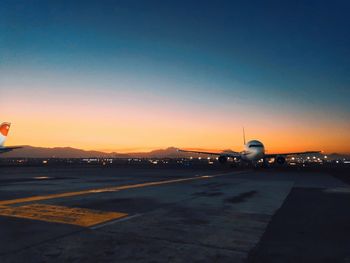 View of airport runway against sky during sunset