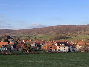 Houses on field by buildings against sky in ershausen, schimberg, eichsfeld, thuringia, germany