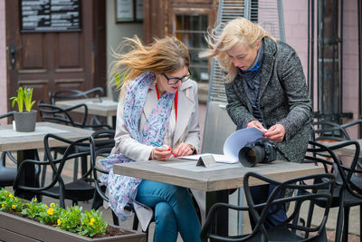 Females looking file at sidewalk cafe