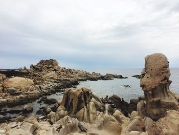 Rocks by sea against sky