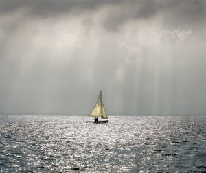 Sailboat sailing on sea against sky