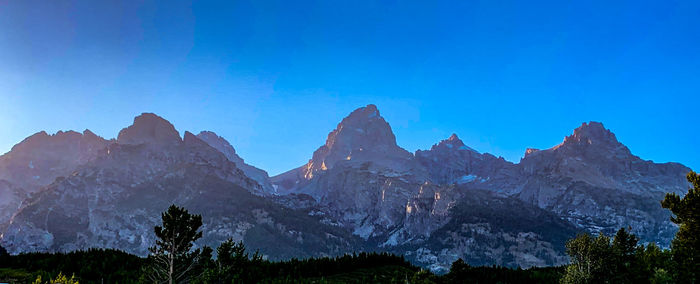 Scenic view of mountains against blue sky