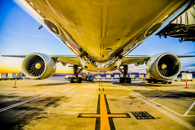 Airplane on airport runway against sky