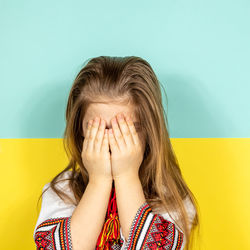 Portrait of young woman against blue background
