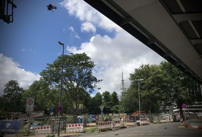 Street amidst trees and buildings against sky