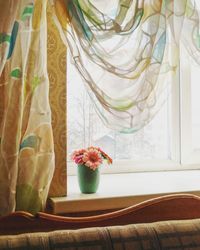 Close-up of flower vase on window sill