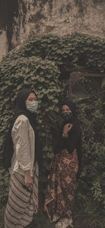 Portrait of woman standing against wall in winter