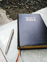 Close-up of bible and pen on table