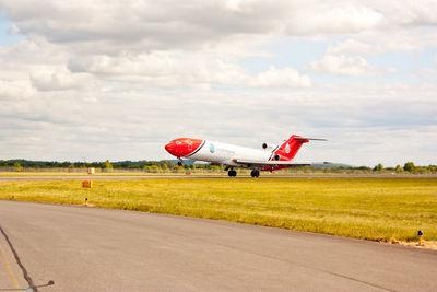 Airplane on airport runway against sky