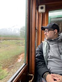 Thoughtful man looking through train window