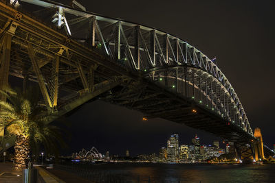 Illuminated bridge over river at night