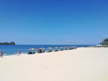 Scenic view of beach against clear blue sky