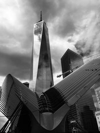 Low angle view of modern buildings against cloudy sky