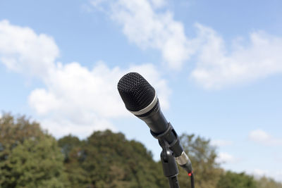 Close-up of microphone against sky