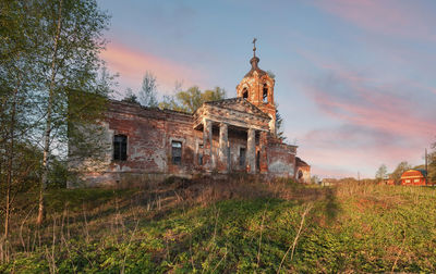 Old building on field against sky