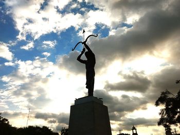 Low angle view of statue against cloudy sky