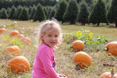 Portrait of girl with pumpkins on field