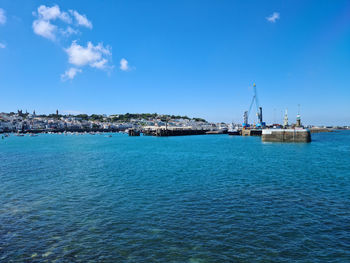 Sailboats in sea against blue sky