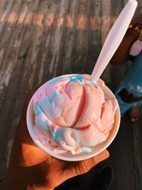 Midsection of person holding ice cream on table
