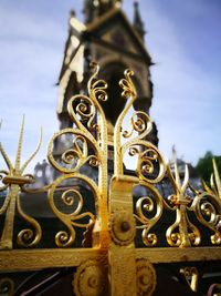 Low angle view of ornate gate against sky