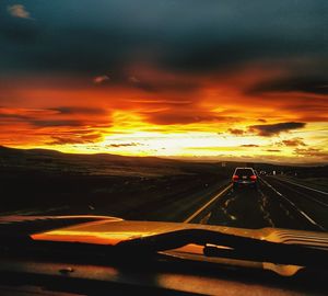 Car on road against orange sky