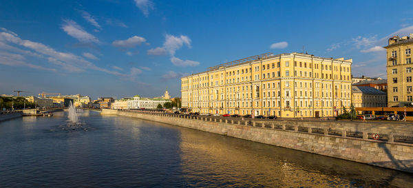 Bridge over river against buildings in city