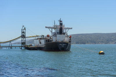 Sailboat sailing in sea against clear sky