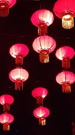 Low angle view of illuminated lanterns hanging at night