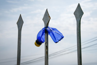 Close-up of metal pole against blue sky