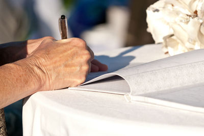Close-up of man reading book on table