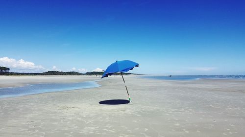 Scenic view of beach against blue sky