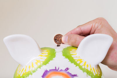 Close-up of hand holding food over white background