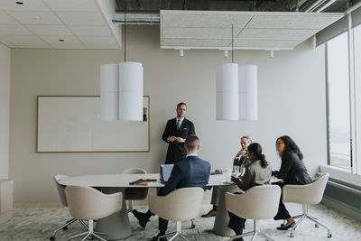 Multiracial business colleagues discussing strategy in board room during meeting