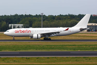 Airplane on airport runway against sky