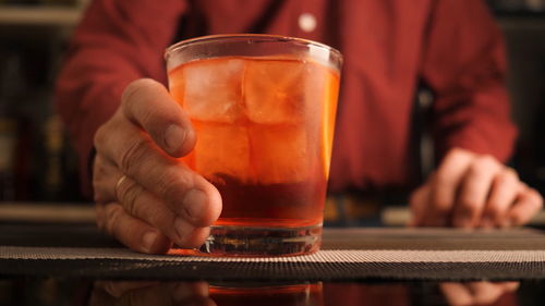 Midsection of man holding beer glass