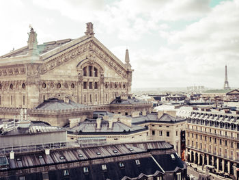 Buildings in city against cloudy sky