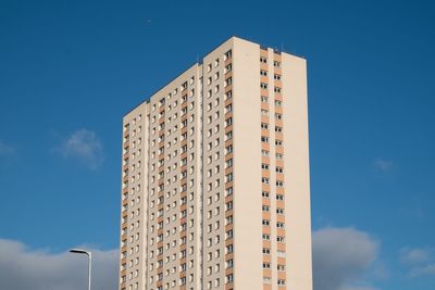 Low angle view of modern building against blue sky
