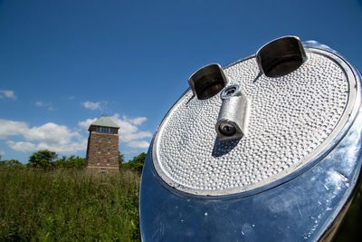 Close-up of abandoned factory against blue sky