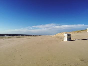 Scenic view of beach against blue sky