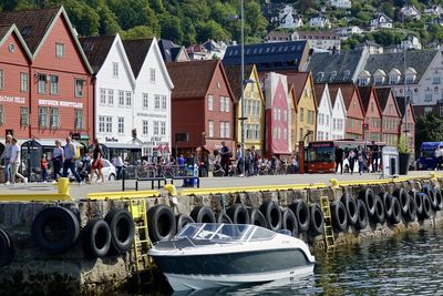 People on boat in river against buildings in city