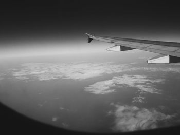 Airplane flying over landscape against sky