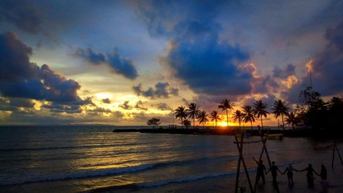 Scenic view of sea against dramatic sky during sunset