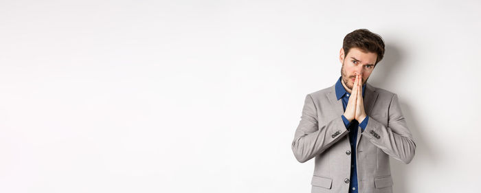 Young man standing against white background