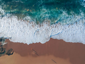 Aerial view of sea waves and sandy beach