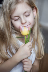 Close-up of smiling girl holding tulip